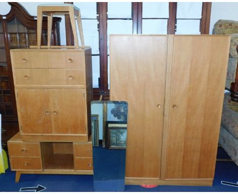 A Meredew mid 20thC light oak bedroom suite, comprising double wardrobe, 176cm high, 123cm wide, 53.5cm deep., a linen press 