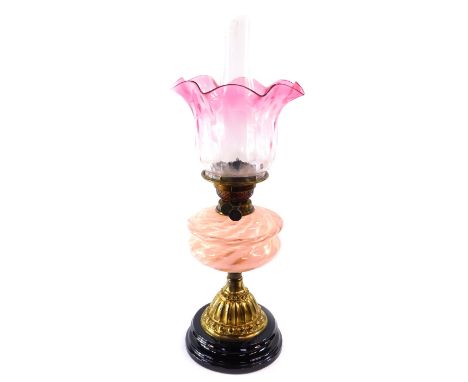 A Duplex early 20thC brass oil lamp, with a pink clear and pearlescent glass reservoir, glass chimney and clear to cranberry 