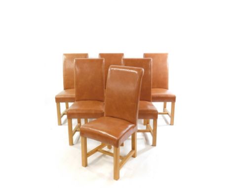 A set of six light oak and tan leather single dining chairs, with over stuffed seats and backs, raised on square legs united 