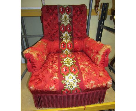 A mid-Victorian upholstered drawing room chair, the crimson and gold fabric with button back arms and seat and deep fringe ba