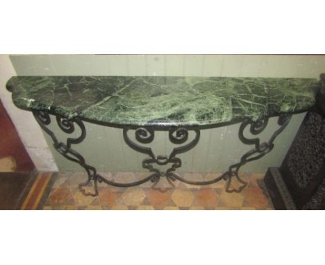 A console table, the green and white flecked coloured marble top with serpentine moulded front raised on an open ironwork bas