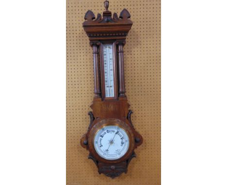 Early 20th century oak aneroid barometer thermometer in an architectural case with Corinthian columns and urn finial, 105 cm 