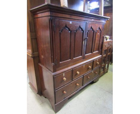 A 19th century oak two sectional linen cupboard, the upper enclosed by a pair of twin arched fielded panelled doors with kite