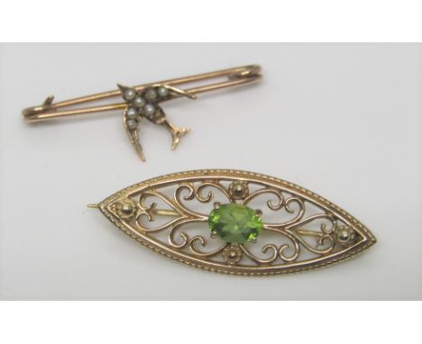 Two 9ct brooches; the first of marquise form cast with scrolled floral decoration and set with a peridot, 3.7cm approx, the s