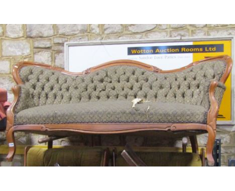 A 19th century three seat canape with serpentine front, upholstered seat, button back and arms within a shaped carved and mou