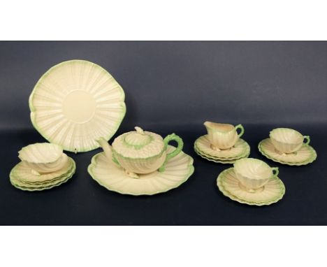 A collection of 19th century Belleek Neptune shape teawares with green tinted borders comprising a teapot, milk jug, sugar bo