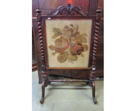 A Victorian fire screen with glazed floral tapestry panel, within a show-wood frame with spiral twist columns and scrolled su