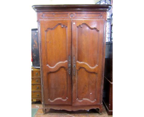 19th century fruitwood armoire, the twin scrolled panel doors enclosing a shelved interior with fancy iron escutcheon, with w