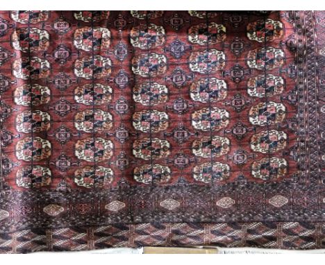 A large Persian carpet with red wine ground field, multi medallion panels within deep and numerous running borders, 380 x 285