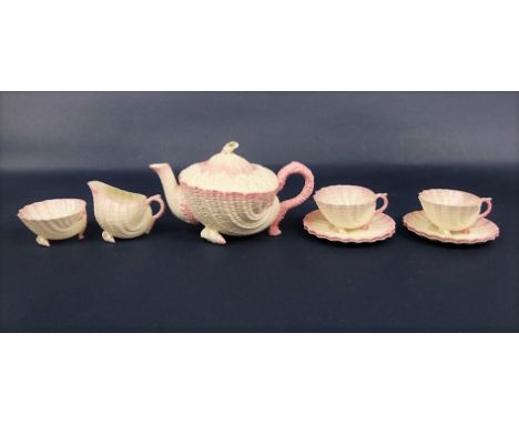 A collection of 19th century Belleek Neptune shape teawares with pink tinted borders comprising teapot, milk jug, sugar bowl,