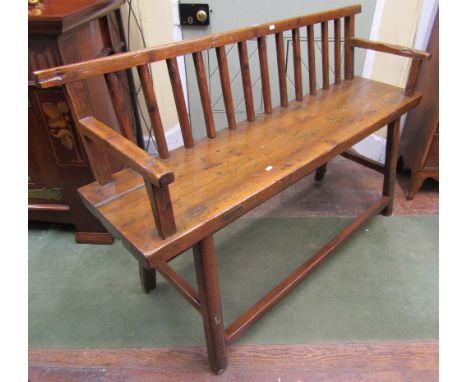 A rustic pine bench with stick back, raised on simple chamfered supports, 142cm wide 