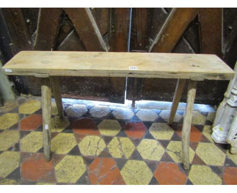 A small rustic pine bench with plank top and through splayed stick supports, 91 cm long x 18 cm wide