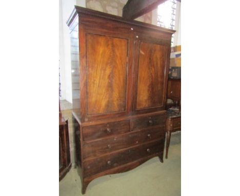 A 19th century mahogany linen press with dentil moulded cornice, the upper section enclosed  by a pair of panelled doors with