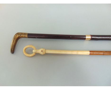 Two slim walking canes, one with an ivory top with hoop handle, the other with enamel inlaid brass knop (2)