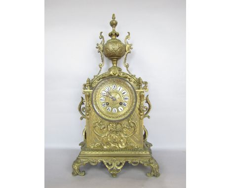 Cast brass lancet mantel clock, mounted by a twin handled campana urn, the circular twin train dial with enamel Roman numeral