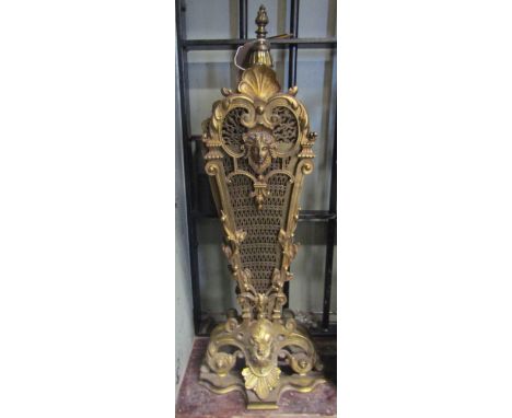 A good quality cast gilt metal framed firescreen with retractable decorative pierced fan shaped panels housed within framewor