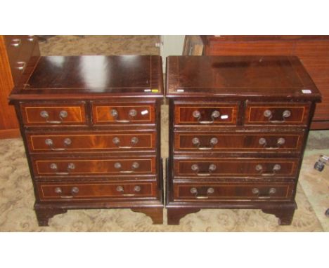 A pair of small reproduction Georgian style mahogany veneered chests of three long and two short drawers, raised on bracket s