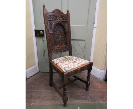 A pair of carved oak hall/side chairs with scrolling acanthus, flower head aqnd further detail, with drop in seats, raised on