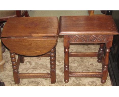A good quality Old English style oak oval drop leaf occasional table with moulded outline and carved frieze raised on turned 