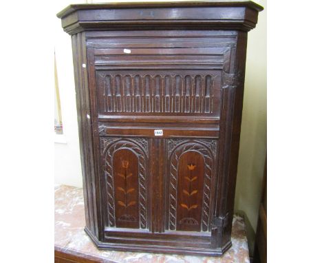 Early Georgian oak hanging corner cupboard, the panel door with carved detail and inlaid tulip marquetry decoration 