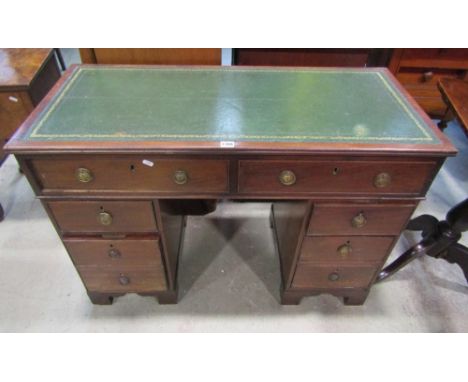 A Georgian style mahogany kneehole twin pedestal writing desk, with green inset leather panel top over an arrangement of six 