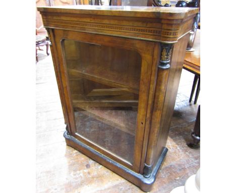 A mid Victorian walnut and figured walnut pier cabinet enclosed by a single glazed panel door, with turned column supports, w