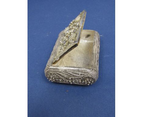 Eastern filigree silver snuff box with various scrolled paisley and floral patterns, the hinged lid enclosing a part gilt int