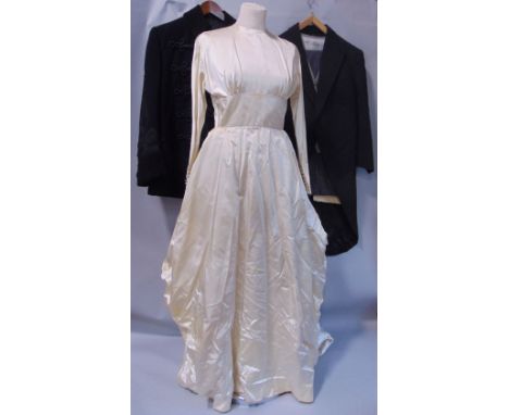 A collection of vintage clothing including an ivory satin wedding dress, men's wedding tailed jacket, waistcoat and trousers,