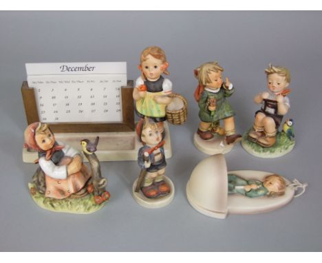 A collection of Goebel Hummel wares comprising a boxed sister perpetual calendar, a wall pocket and four figures
