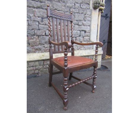 A pair of 1920s oak rail back carver chairs, with scrolled arms, drop in seats, raised on turned bobbin and block supports