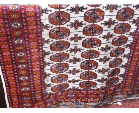 An eastern wool rug with multi medallion centre upon a white field within alternating and repeating red ground border, 250 x 