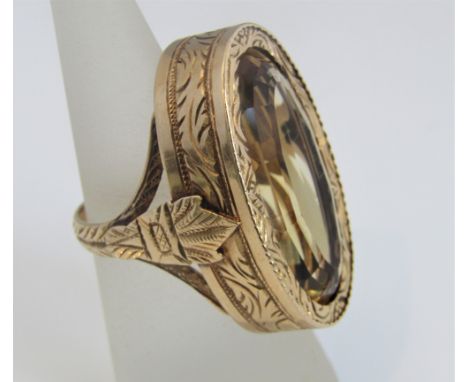 Early citrine ring, the oval stone in a fancy engraved mount with strap-work and bracket decoration in unmarked gold, citrine