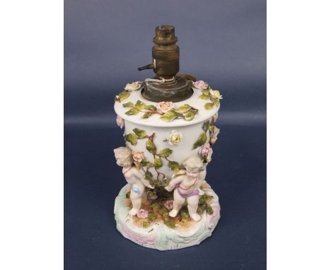 A 19th century continental two sectional ceramic lamp base with applied figures of four cherubs and encrusted floral detail a