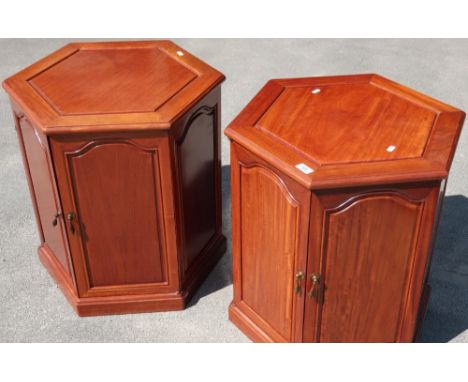 Pair of Eastern hardwood lamp tables, hexagonal top, single shelf enclosed by two panelled doors 