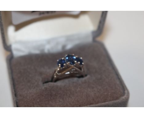 A white metal ring marked 14K, set with blue stones, ring size J, approx. 4.5gms 
