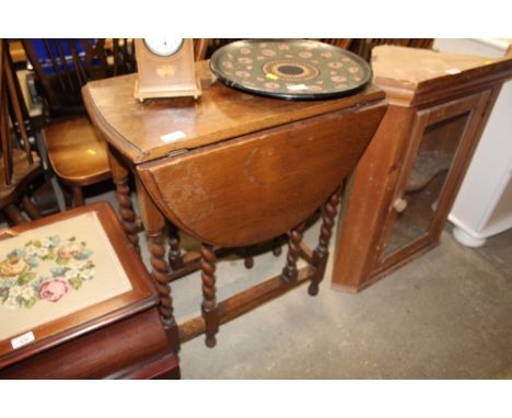 A 1930's oak gate leg tea table on spiral twist supports