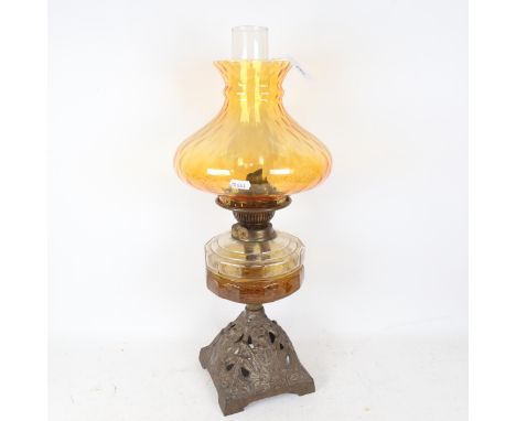 An early 20th century brass oil lamp, with amber glass font and shade, overall height 55cm 