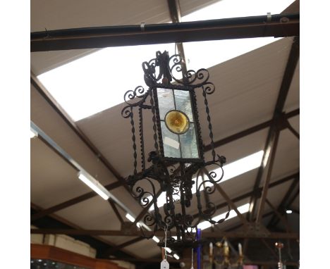 A wrought-iron ceiling light fitting, with frosted and coloured glass panels, height 75cm (2 panels detached but still presen