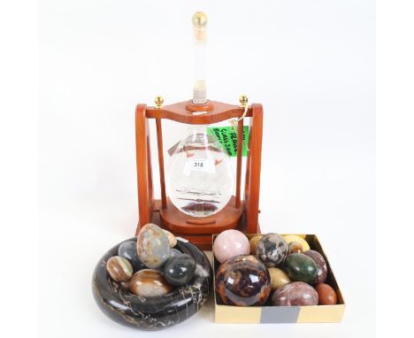A group of hardstone eggs, veined marble bowl, bottle of Via Roma Distillati Grappa 