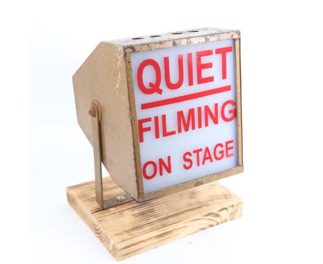 A Vintage painted tin illuminating filming stage lamp, Quiet Filming On Stage, with swivel wall bracket mounted on pine plint