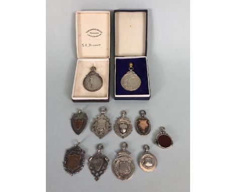 Collection of hallmarked silver watch chain fobs and sporting medals, approximately 79.41g total, and a stone set silver moun