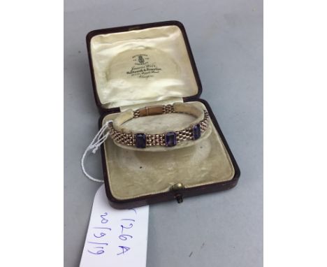 EDWARDIAN GILT BRACELET, set with three amethyst coloured stones