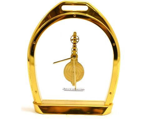 A brass stirrup shaped mantel timepiece, signed Jaeger LeCoultre, 20th century, glazed panels with a visible single line leve