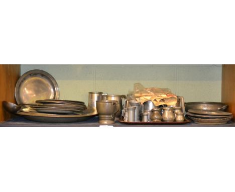 Shelf of assorted pewter including 18th/19th century dinner plates, a large charger, 20th century pewter tankards, two commem