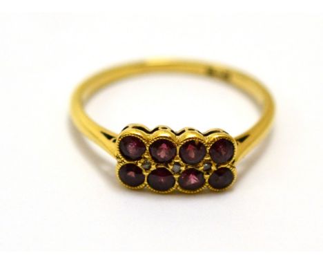 A ruby and diamond two row ring, eight round rubies with rose cut diamond accents, in yellow millegrain settings on a plain p