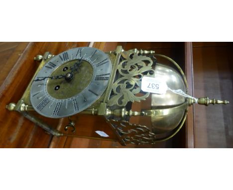 A striking lantern type mantel clock, early 20th century, four posted case with side doors, scroll frets, 6-1/2-inch silvered