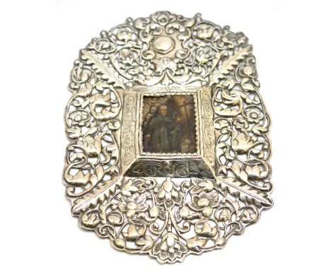An Indo Portuguese pierced silver frame enclosing an oil on metal portrait of a saint, the silver with 17th century style mot