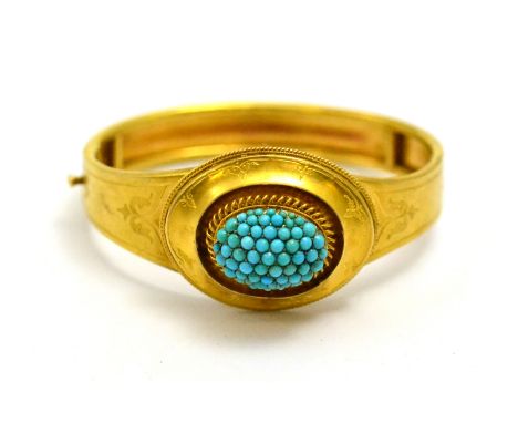 # A Victorian bangle, with a cluster of cabochon turquoise to the centre, rope twist and engraved decoration, hinged to a pla
