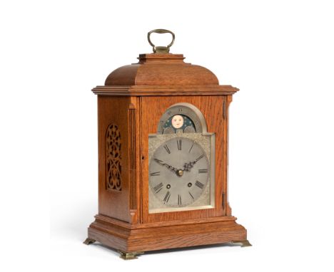 An oak quarter striking table clock with a moonphase display, circa 1900, caddied top with carrying handle, side sound frets,