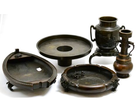 A collection of Japanese bronzes including an ikebana flower arranging vase, a twin handled vase, a lotus shaped dish (one pi